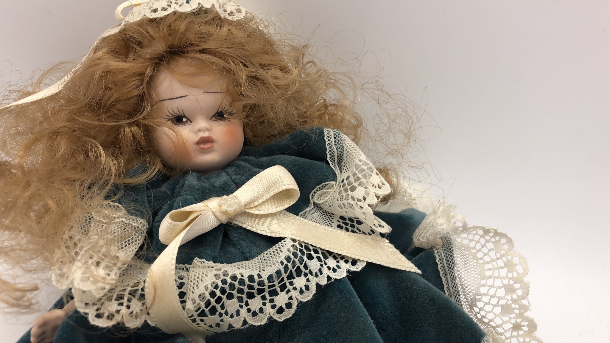 Bambola di porcellana con abito verde