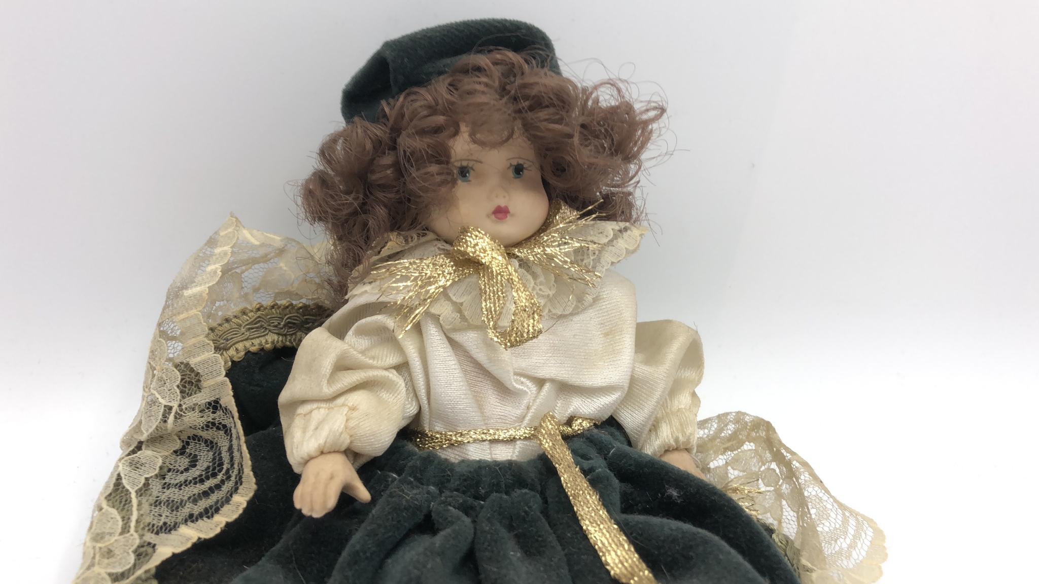 Bambola di porcellana con abito di velluto verde