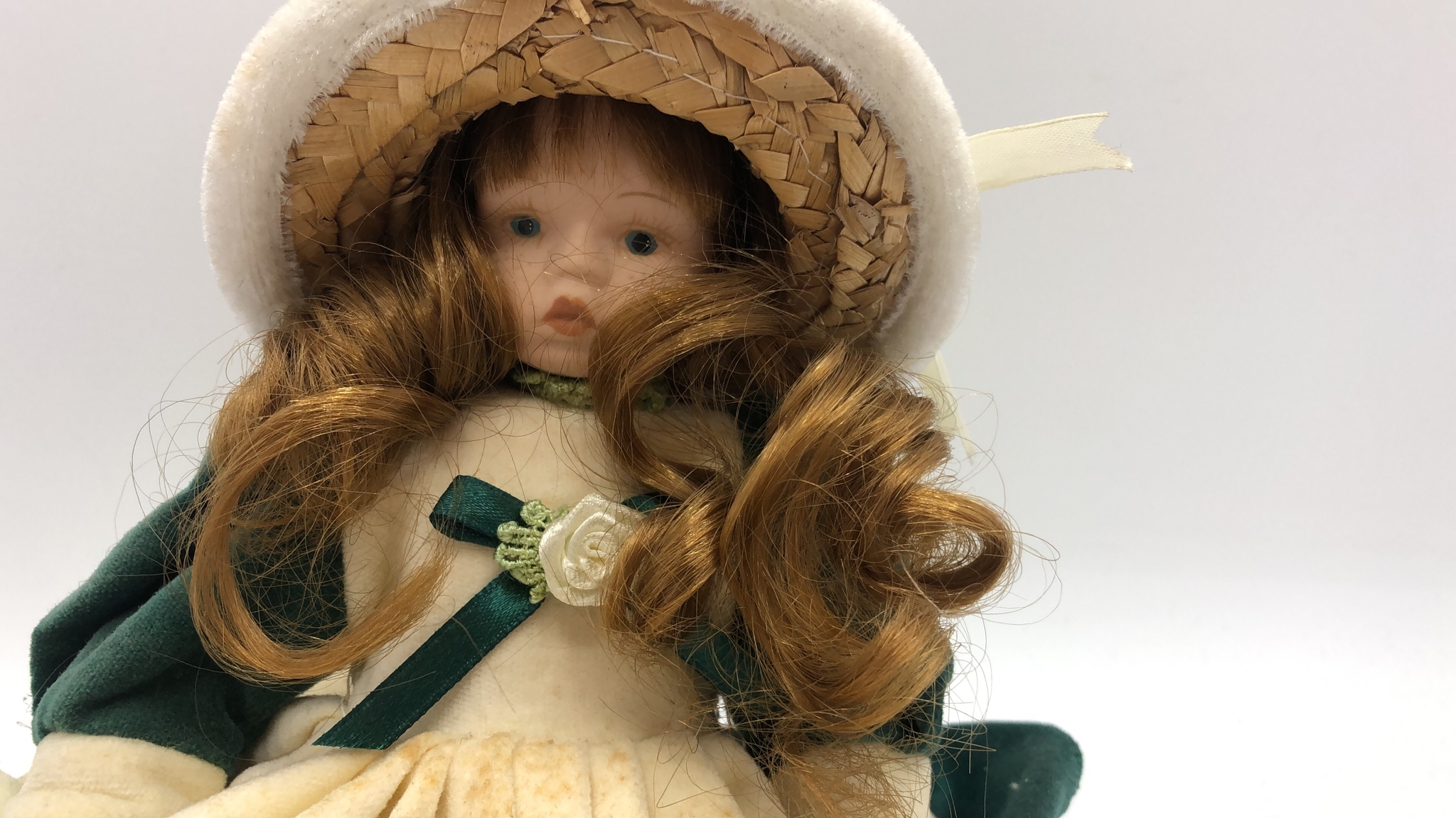 Bambola di porcellana in abito verde
